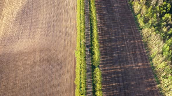 Flying Over Rural Road with Cars Among Agricultural Fields at Summer Sunny Day