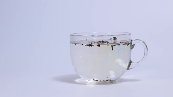 Brewing Dry Tea Leaves in a Transparent Cup