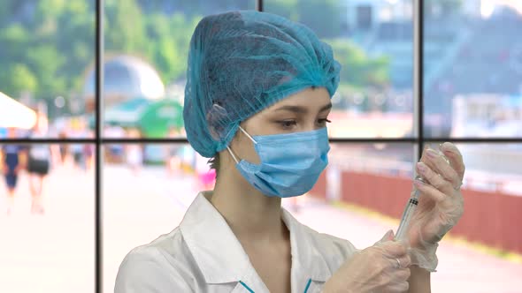 Young Nurse Filling Syringe with Medicine From the Vial alt