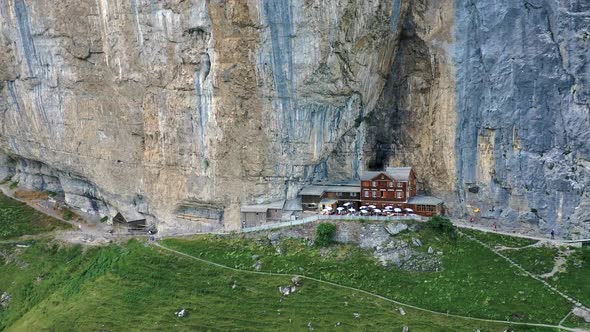 Flying Around a Restaurant Under a Cliff on Mountain Ebenalp in Switzerland alt
