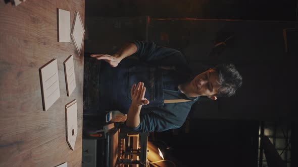 Vertical Video of Confident Young Craftsman Stands Near a Work Table in a Carpentry Workshop alt
