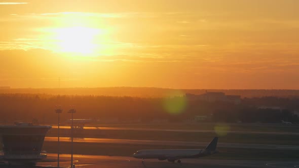  - Airport View with Moving Plane at Golden Sunset alt