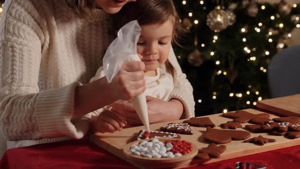 Mother and Daughter Decorating Gingerbread at Home