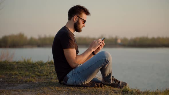 Guy Taking Photo of Sunset With Mobile Telephone. Man Taking Picture On Mobile Phone. alt