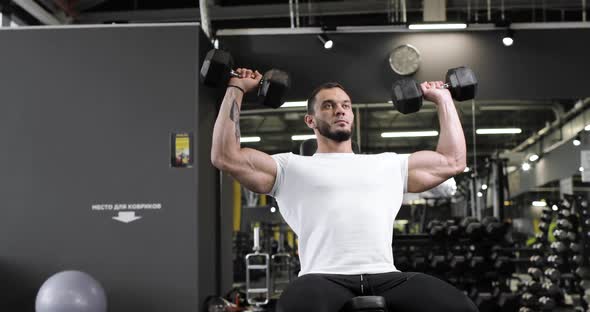 Active Bodybuilder Young Man Lifting Heavy Weights Black Dumbbells Concentrating Working Out Alone