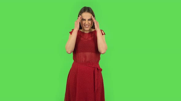 Tender Girl in Red Dress Is Suffering From Headache From Fatigue. Green Screen alt