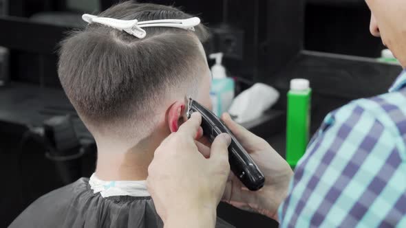 Professional Barber Giving a Haircut To a Male Customer alt