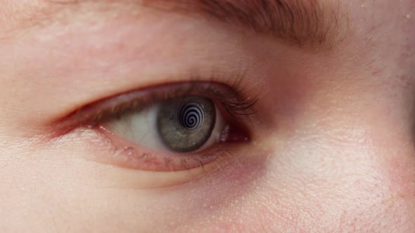 Closeup of a Eye Blinking Opening and Closing Hypnotic Spiral Reflection in Eye alt