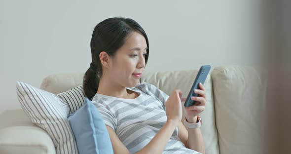 Woman Use of Mobile Phone and Sit on Sofa at Home