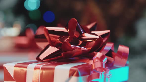 A New Year's gift with a red bow revolves around an axis, the concept of new year and christmas.