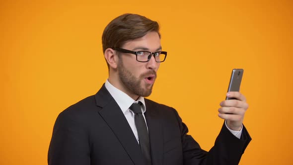 Man Looking at Smartphone and Doing Yes Sign, Favorable Credit Term, Betting alt