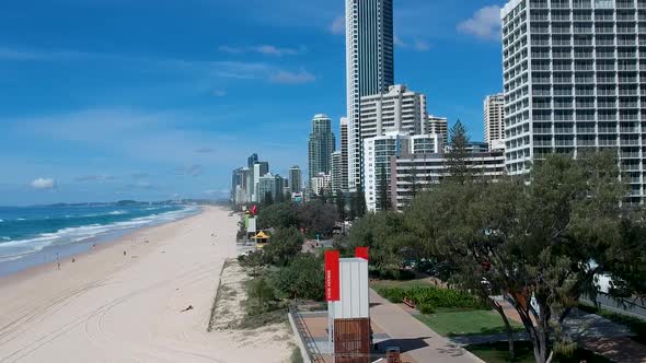 A rising aerial view of the coastal town showing the high-rise buildings built along the beach front alt