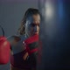 A female boxer trains on a punching bag in the gym