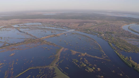 Aerial Drone Footage of a Freight Train Passes a Bridge in High Water