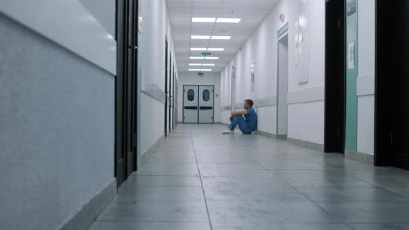 Professional Medic Resting Alone in Hospital Corridor alt