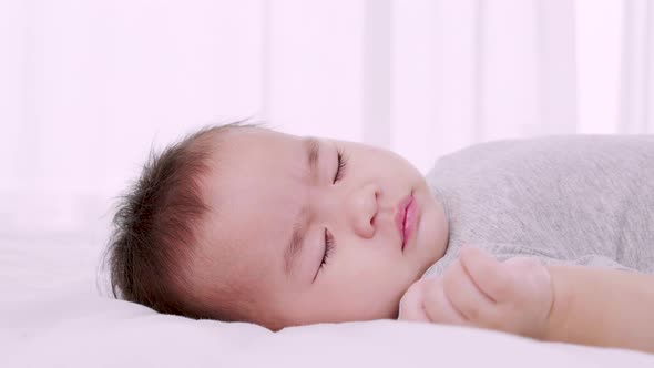 baby sleeping on the bed in the home during the daytime, Close-up shot, Slow motion