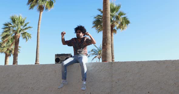 Young african american man listening music with vintage boombox stereo outdoor alt
