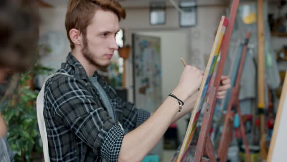 Zoom-out Portrait of Art School Students Guy and Girl Drawing in Class Busy with Creative Activity alt