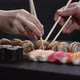 Man and woman pick up sushi with chopsticks at the same time - VideoHive Item for Sale