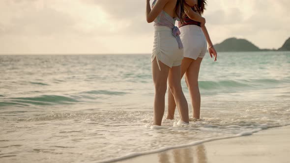 Two Asian girl friends are having fun on the beach while on vacation. concept of freedom, travel,