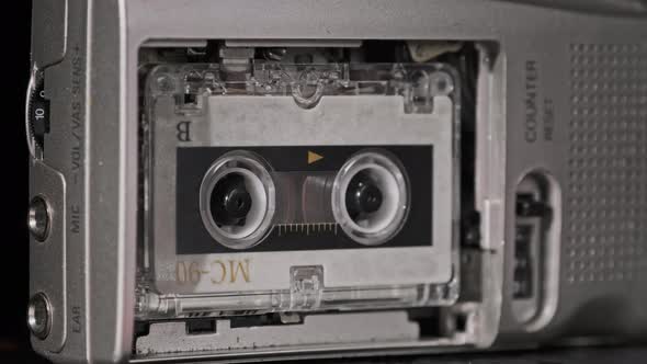 Audio Cassette in the Tape Recorder Playing and Rotates alt