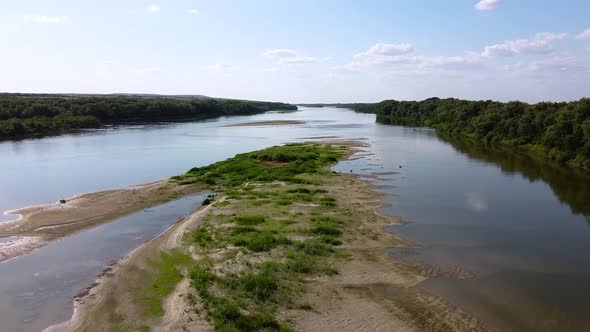 A beautiful river with a sandy island covered with green grass