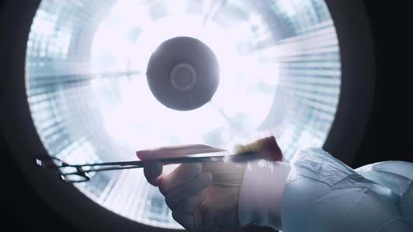 Patient watching doctors' hands above operating table