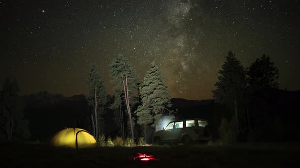 Time Lapse of Camping with a Car, Tent and Campfire at Night