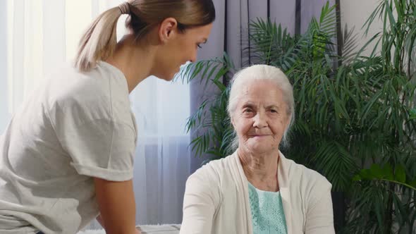 Female Caregiver Helping Old Woman to Do Dumbbell Exercise 