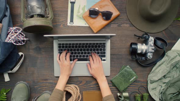 Top View of Hands Typing on Laptop and Preparing for Trip alt