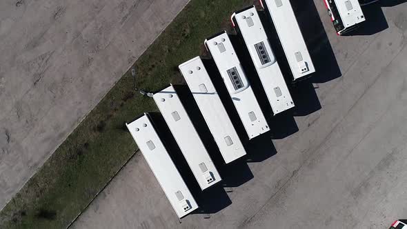 drone eye's bird top down view of line of public white bus parking in a station in the city center o alt