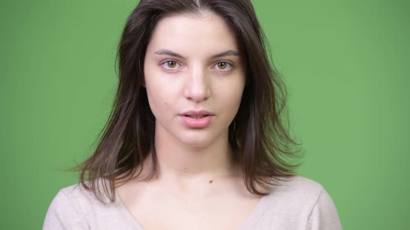 Young Beautiful Woman with Finger on Lips alt