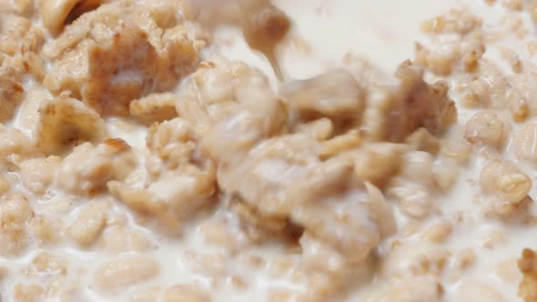 Fresh cornflakes and cereales mixing in the bowl with milk 4K 2160p UHD video - Muesli and milk heal alt