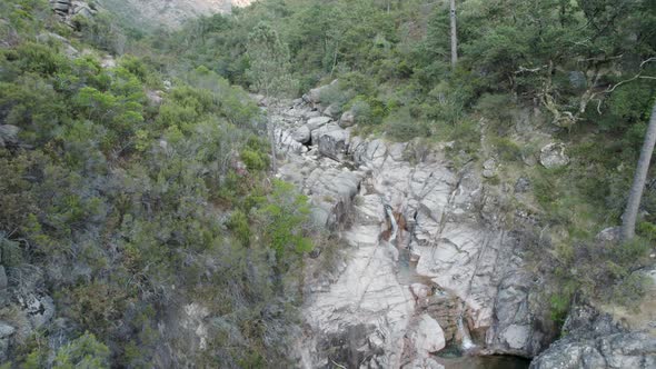 Aerial slowly pullback reveal Idyllic scenery, river stream cascade, Gerês - Portugal