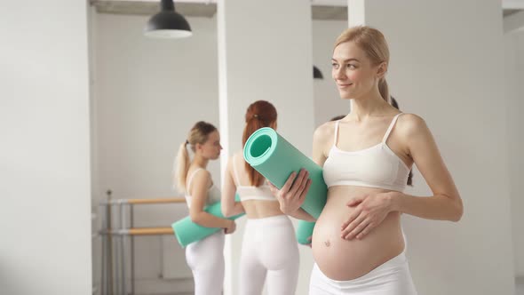 Goodlooking Momtobe Woman with Fitness Mat in Studio Before Yoga