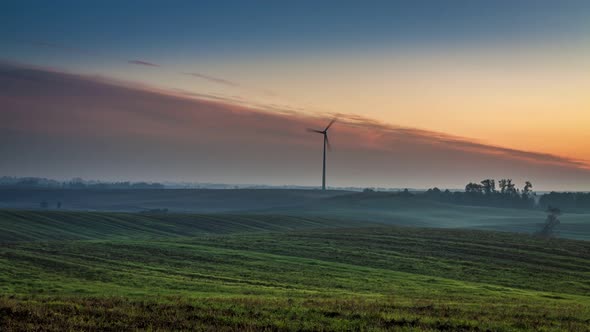 Beautiful sunrise over a field with a windmill in autumn, timelapse, 4K alt