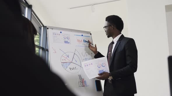 Young Businessman Conducts Presentation Using Whiteboard alt