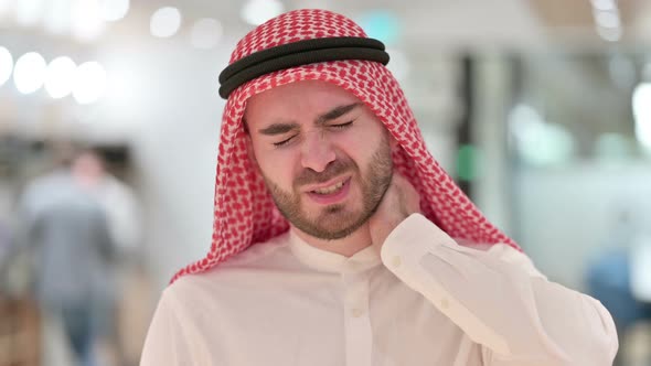 Portrait of Stressed Young Arab Businessman Having Neck Pain alt