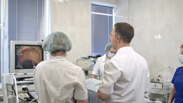 Team of doctors using endoscopic equipment during operation