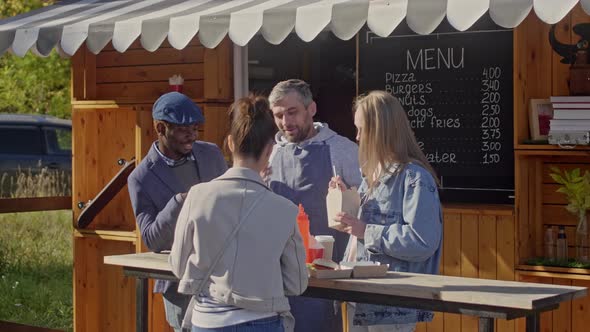 Speaking Group of people standing near street food trailer