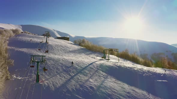 Old Ski Station on a Snowy Mountain Slope with a Lot of People on Skis and Snowboards alt