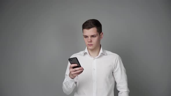 A Young Guy is Using a Mobile Phone