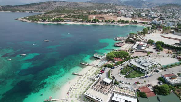 Aerial Azure Beach with Empty Sun Loungers and Boats Balkan Sea Coast Albania alt