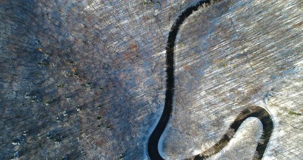 Top View Aerial Winding Road in Winter Woodland 4K
