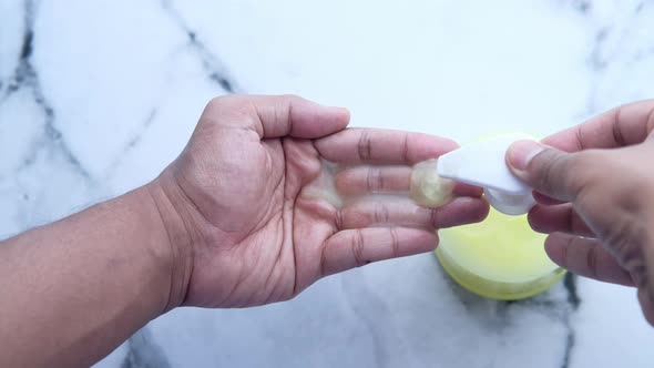 Young Man Washing Hand with Soap Bottle  alt