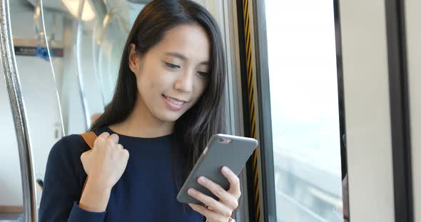 Woman use of cellphone inside train compartment alt