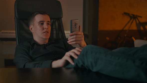A Man Makes a Video Call Through a Smartphone in a Homecozy Interior alt