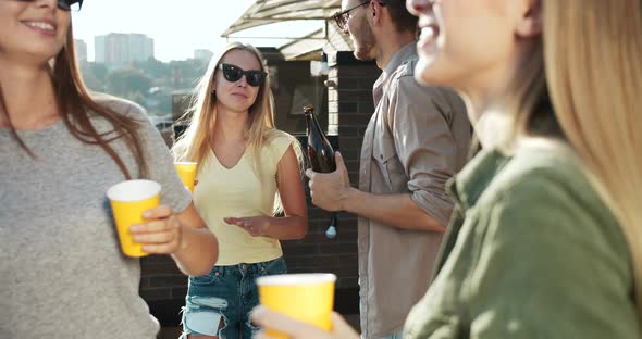 Friends Chatting and Drinking on Balcony