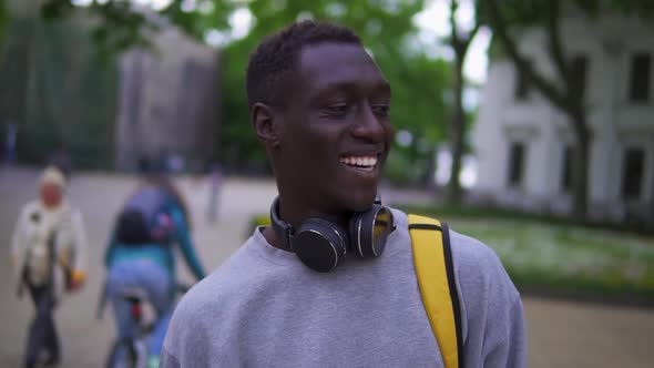 Close Up Portrait of Handsome Young African American Man Smiling Cheerful at Camera Enjoying Calm alt