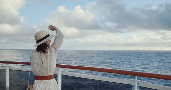 Young girl waving from a ship alt